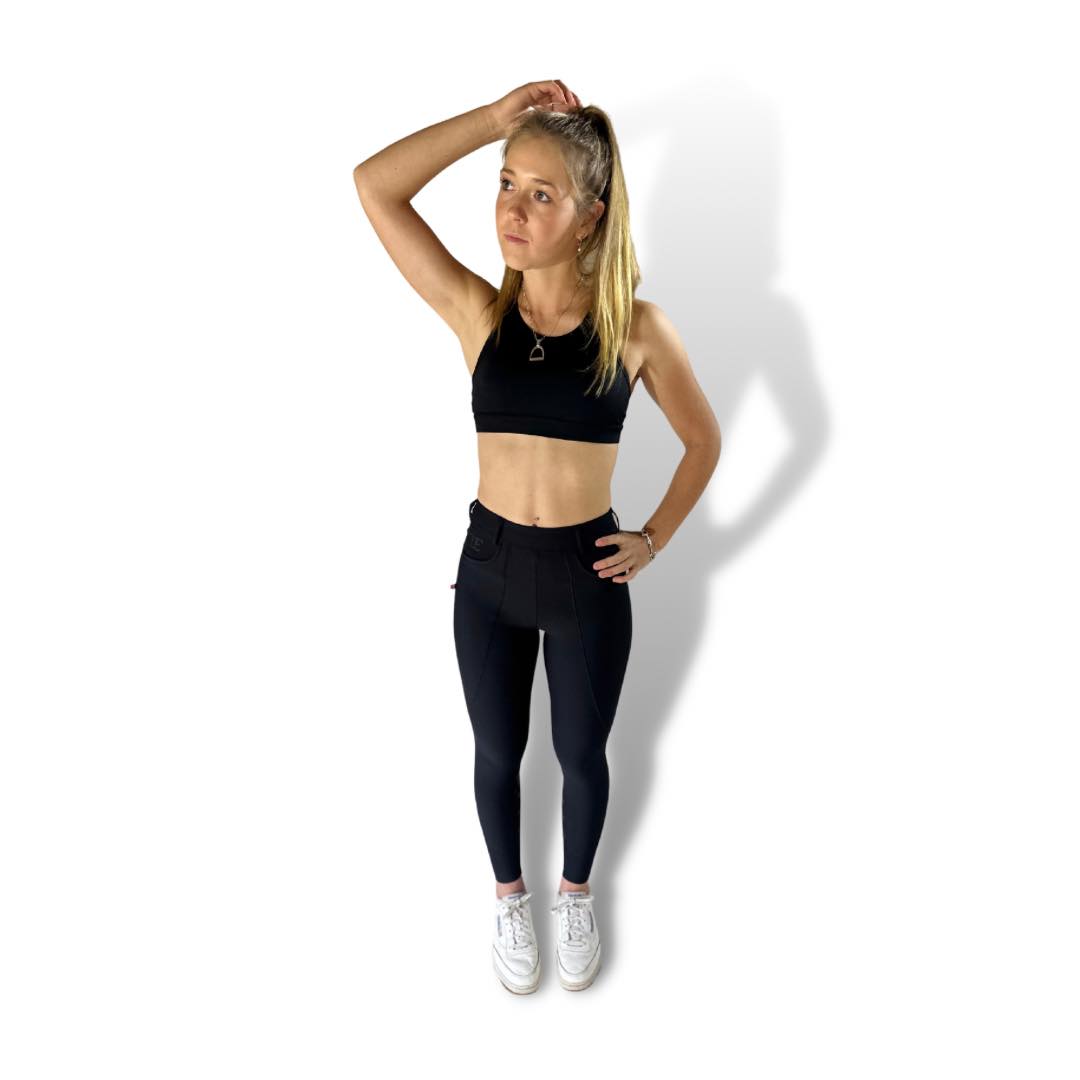 Blonde woman in black workout attire posing in Staple Black Breeches for riding