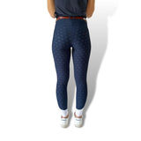 Navy blue textured leggings styled with white sneakers and a brown belt for riding tights