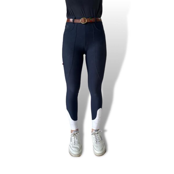 Navy blue high-waisted breeches with a brown belt, white socks, and sneakers