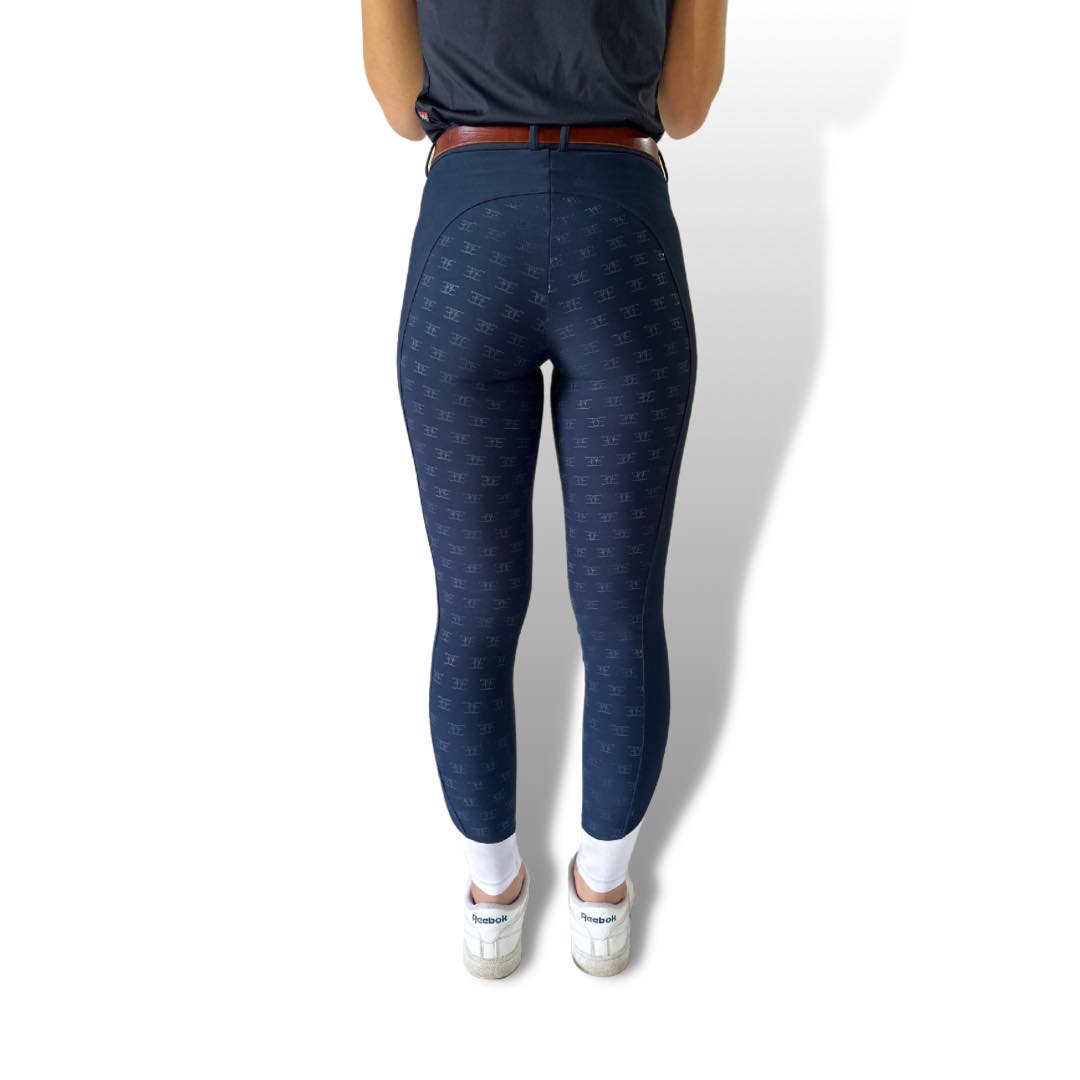 Navy blue textured leggings paired with white sneakers and a brown belt for riding tights
