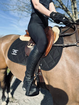 Horse ridden by a rider in black boots and gloves with Equus Elite Saddle Pad