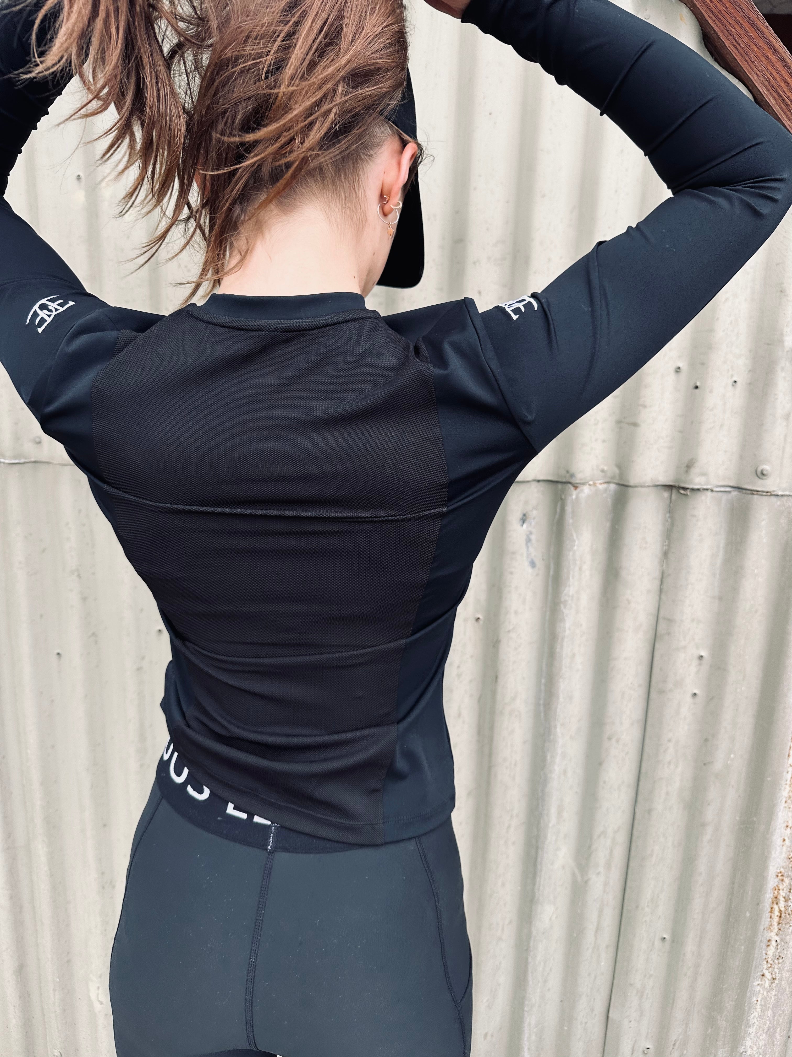 Woman in long sleeve athletic top and leggings, showcasing Evolution 2.0 Performance Shirt