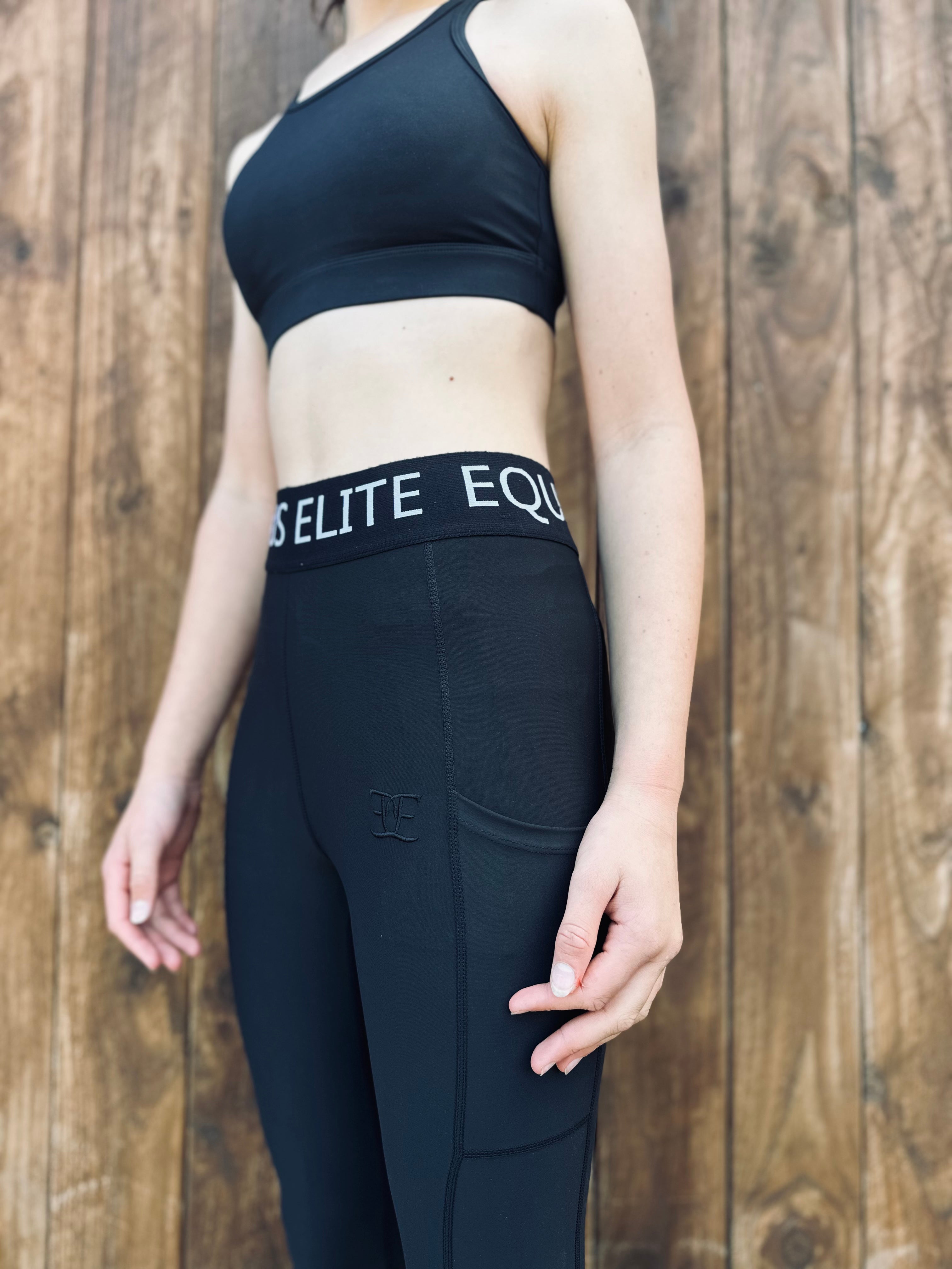 Woman in black athletic wear showcasing Equus Elite Gym Tights with ELITE EQ waistband