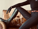 Sleeping dog on leather couch between legs in Staple Black Breeches and riding boots